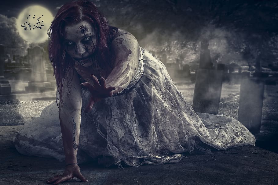 A zombie woman with bloody hands crawling toward the viewer